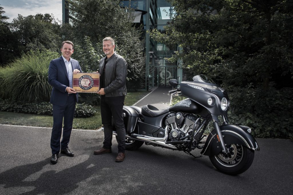 Alain Zimmermann, CEO of Baume & Mercier, with Grant Bester,Vice President, Indian Motorcycle EMEA, celebrate their partnership in front of a Chieftain Dark Horse® motorbike.