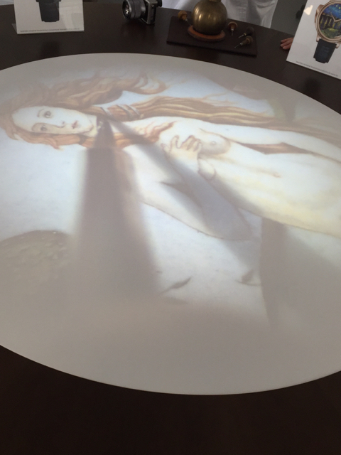 As the artists are hand painting the dial, the image is live-streamed onto a table in the center of the room. 