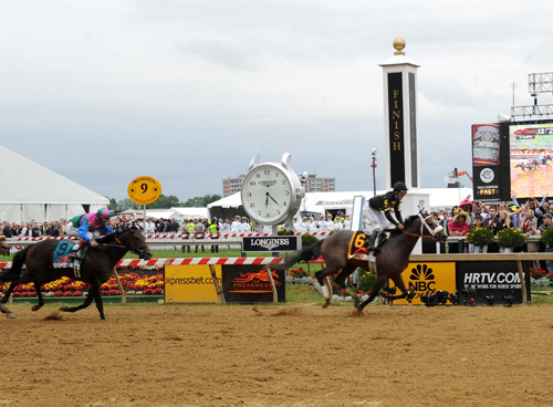 Oxbow races by the Longines clockat the finish line of the 138th running of the Preakness STaesk yesterday. (photo: Diane Bondareff/Invision for Longines/AP Images)