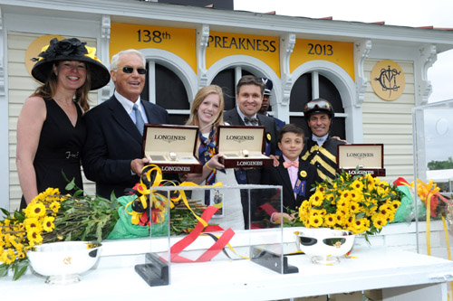 Juan Carlos-Capelli, center, with his son Thomas, and Jennifer Judkins, left, both of Longines, award trainer D. Wayne Lukas, second left, jockey Gary Stevens and Erin Kelley, daughter of owner Brad Kelley, with their Longines St. Imier chronographs after their horse Oxbow won the 138th Preakness Stakes, May 18, 2013, in Baltimore, MD.  (Diane Bondareff/Invision for Longines/AP Images)