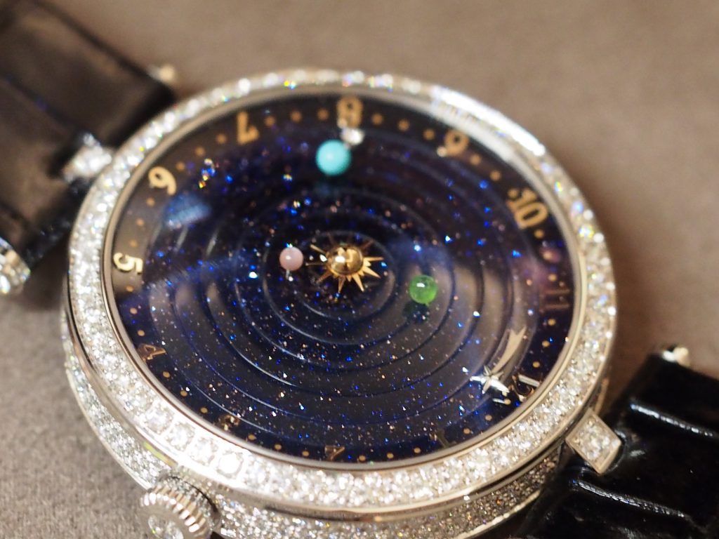 The case and bezel of the Van Cleef & Arpels Lady Arpels Planetarium watch is set with diamonds.