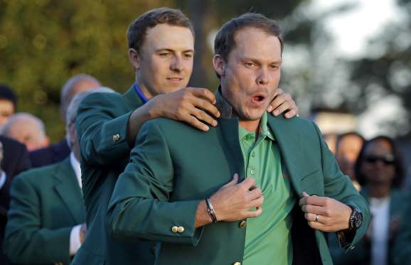 Willett donning the Green Jacket (being helped by Spieth). Photo courtesy of Christ Carlson/AP